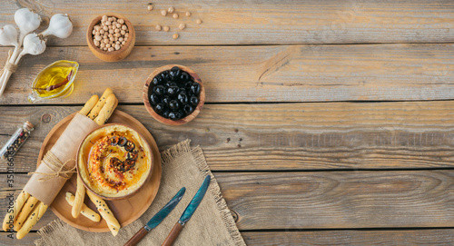 Healthy breakfast with homemade hummus, black olives and crispbread on wooden background. Diet and Healthy snack food
