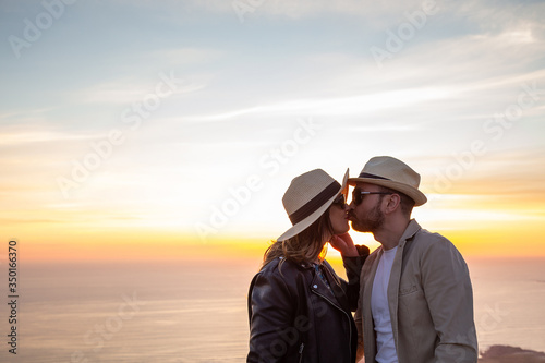 Lovers with hat kissing with the sunset © ROBERTO