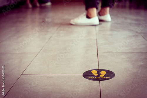 Stand here foot sign or symbol on the floor in coffee shop