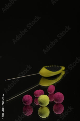 bright green, red boilies, fishing baits for carp isolated on dark background. photo