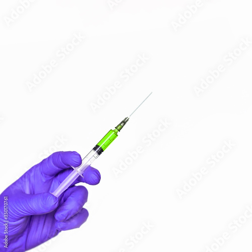 Doctor hand hold syringe in purple glove. Injection yellow vaccine concept. Medical injector for science test. Close up health care vaccination. Therapy drug surgery banner with copyspace