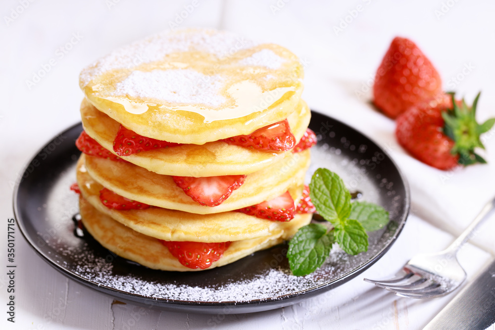 Pancakes with fresh strawberries and maple syrup