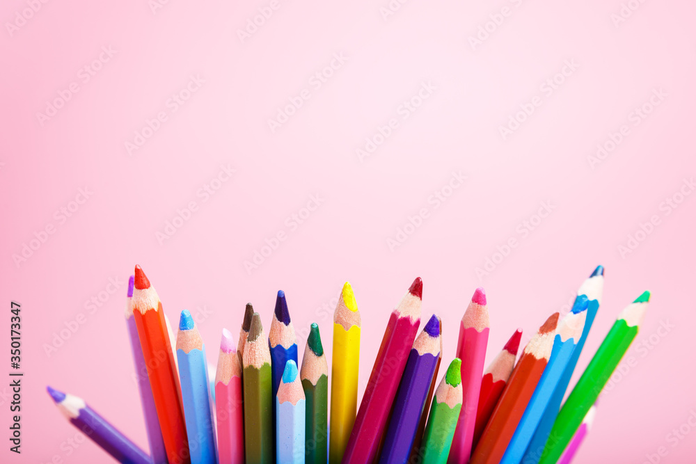 color pencils on a pink background. concept of drawing, art goods store. hobby concept for children. copy space. color pencils on a pink background. concept of drawing, art goods store. hobby concept for children. copy space.