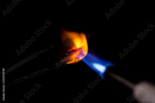 coconut charcoal for hookah is heated by a gas burner isolated on black background with copy space for your text