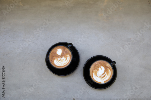 Two Cups of hot cappuccino on white wooden table background.