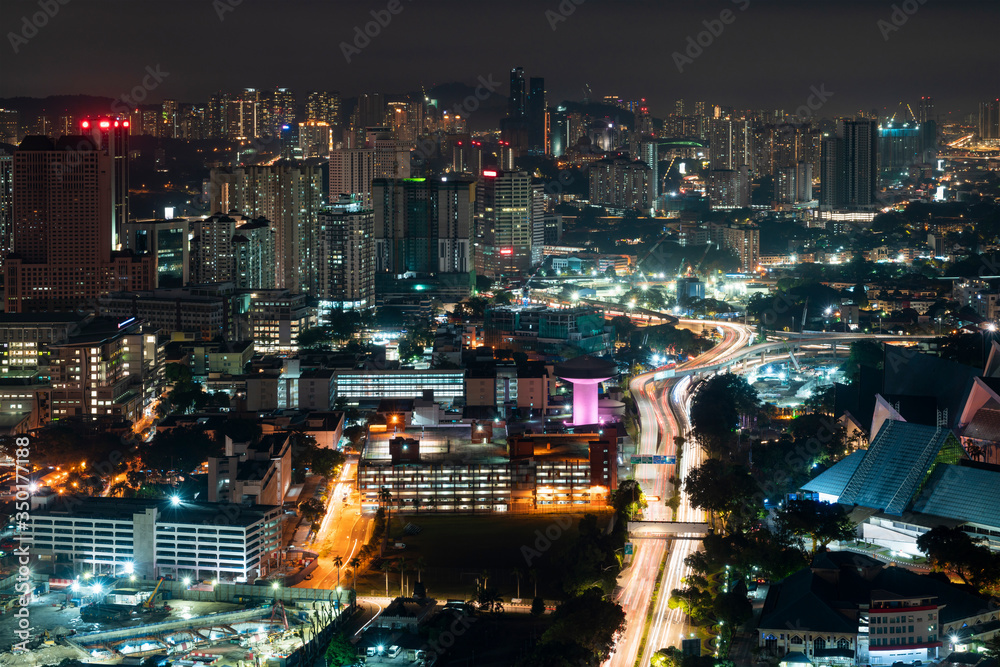 Panoramic view of Kuala Lumpur skyline at night time. City center of capital of Malaysia. Illumination lights contemporary buildings exterior with glass.