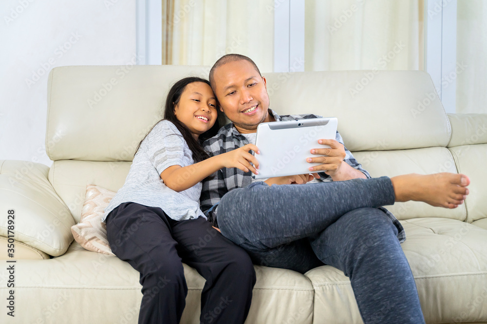 Father and child using a digital tablet at home Father and child using a digital tablet at home