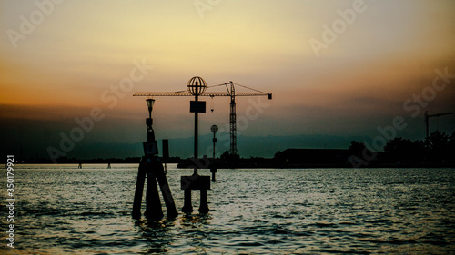 sunset in the sea and crane in the background 