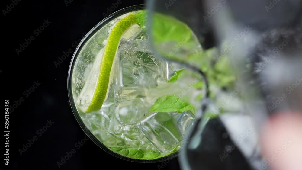 Close-up refreshing soda tonic. Pour carbonated water into a glass of lime and ice. Cold Mojito lemonade