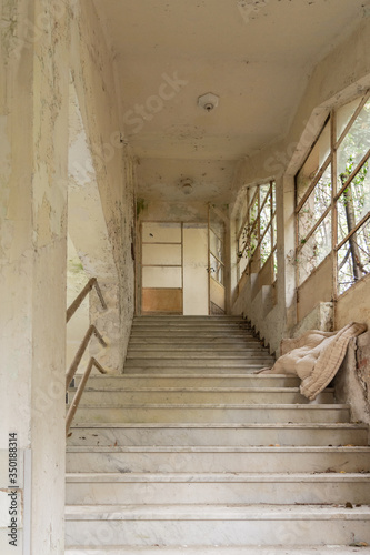 Old abandoned stair in decay building in Italy with yellow wall and nature that grow inside