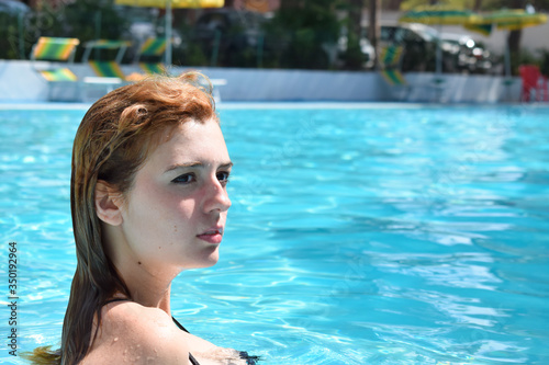 No make up Girl with yellow-orange wet hair in the pool © Davide Cadeddu