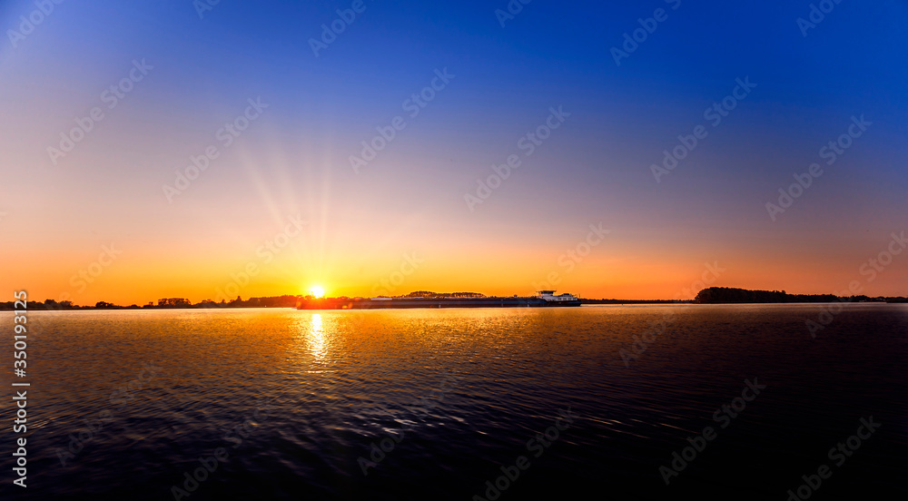 Binnenschiff auf dem Rhein bei Sonnenuntergang Binnenschiff auf dem Rhein bei Sonnenuntergang