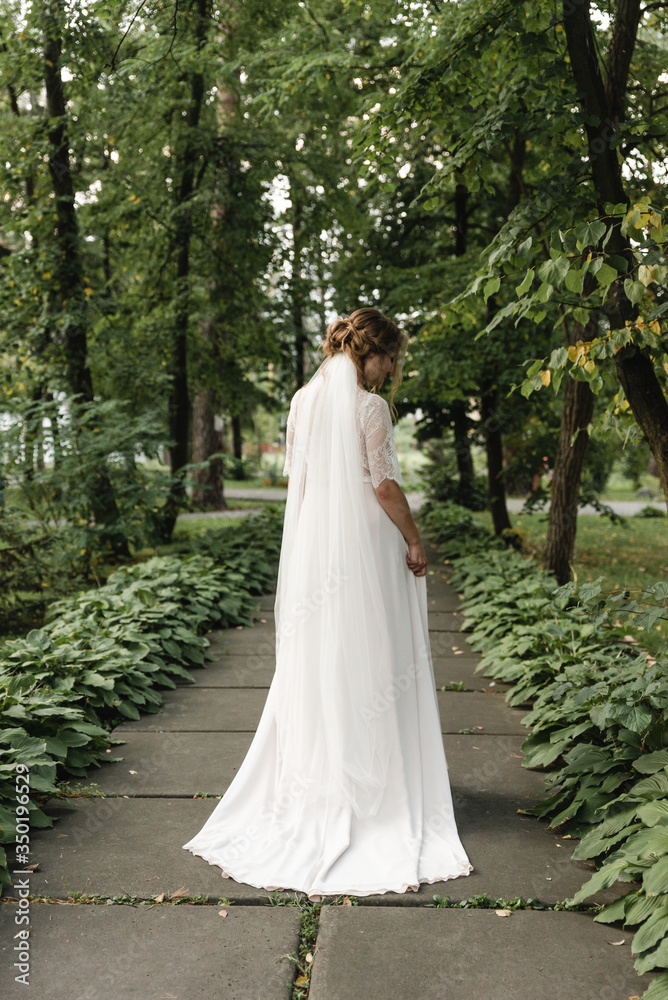 bride stands with her back,young bride stands outdoors rear view,wedding day bride,bride on the street