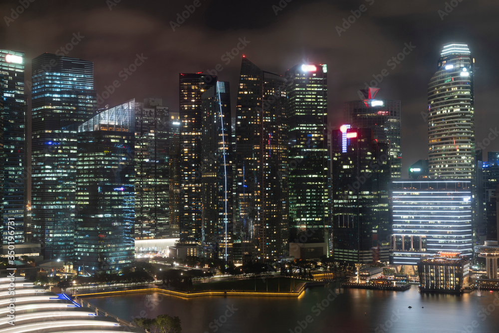 Picturesque panoramic view of Singapore city at night time. Financial and trading center hub in Asia region. Concept of success. Modern buildings in high-tech world. Picturesque panoramic view of Singapore city at night time. Financial and trading center hub in Asia region. Concept of success. Modern buildings in high-tech world.