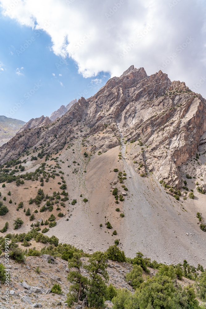 The beautiful mountain trekking road with clear blue sky and rocky hills in Fann mountains in Tajikistan