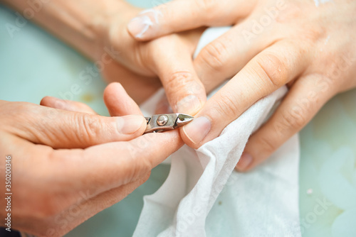 man make hygienic manicure in a beauty salon. A hand holding a piece of paper. High quality photo