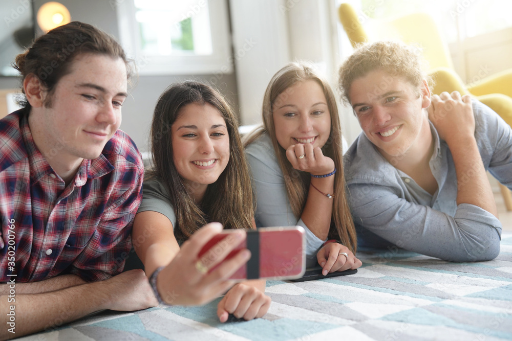 group of four young people with their phone group of four young people with their phone