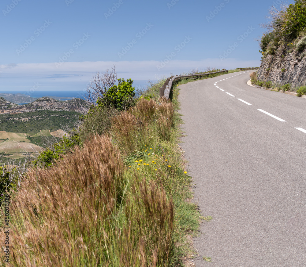 Narrow panoramic road cutting through stone in the mountain, in Corsica Narrow panoramic road cutting through stone in the mountain, in Corsica