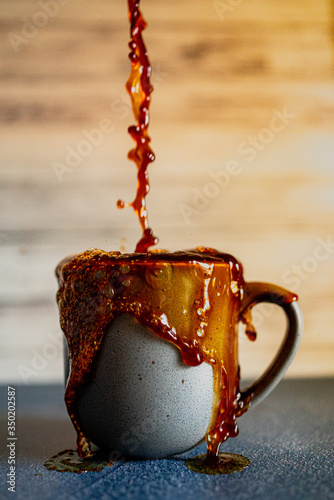 Foto Overflowing cup of coffee with gray mug.
