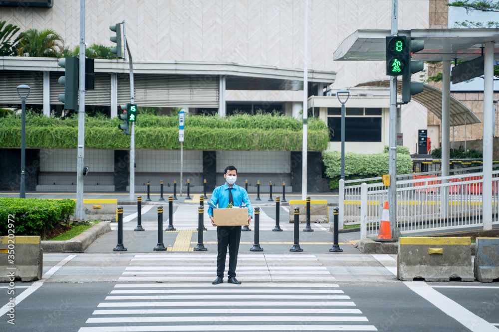 Sad businessman carrying box after fired on street Sad businessman carrying box after fired on street