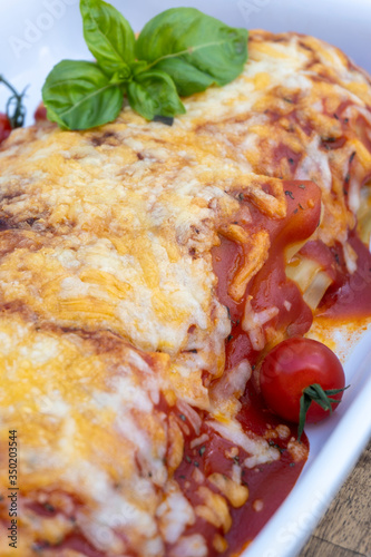 homemade lasagna presented in a vol and served on the table