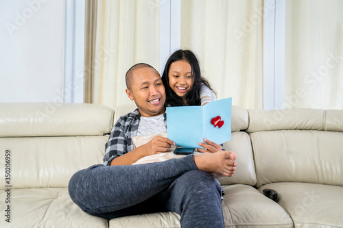 Young man reads a greeting card from his daughter