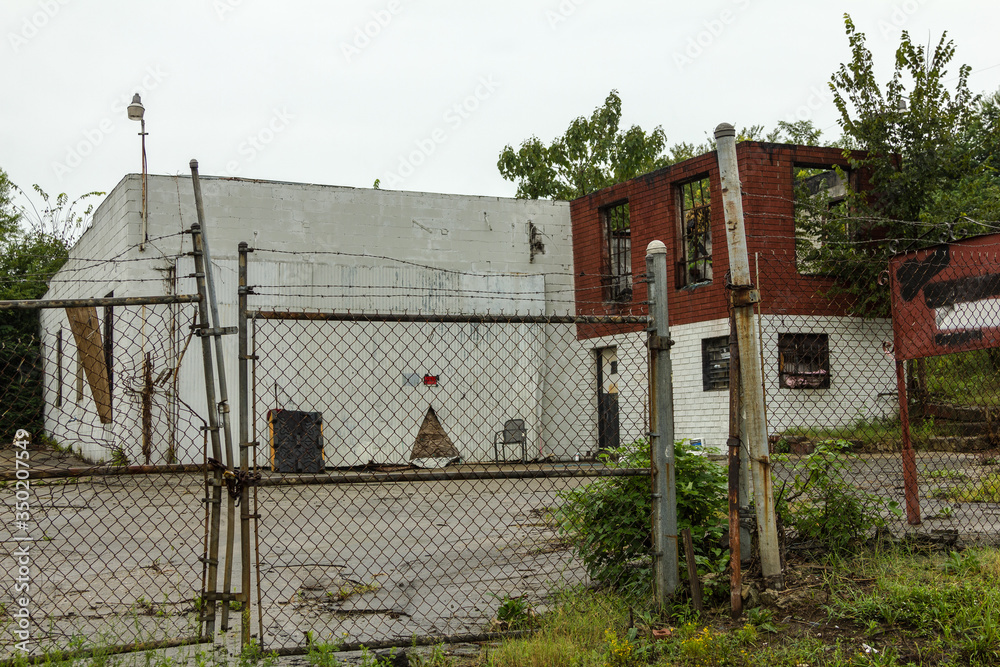 Abandoned warehouse building left to rot in vacant lot with overgrown brush in urban Atlanta Abandoned warehouse building left to rot in vacant lot with overgrown brush in urban Atlanta