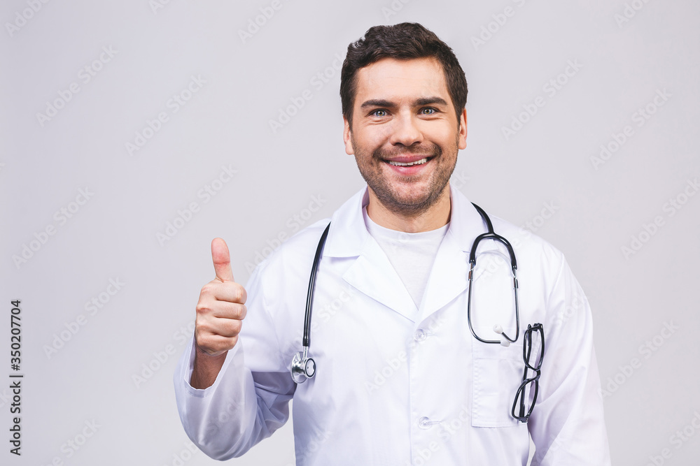 Portrait of a friendly young doctor man smiling giving thumbs up isolated over white background. Portrait of a friendly young doctor man smiling giving thumbs up isolated over white background.