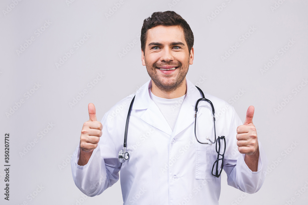 Portrait of a friendly young doctor man smiling giving thumbs up isolated over white background. Portrait of a friendly young doctor man smiling giving thumbs up isolated over white background.