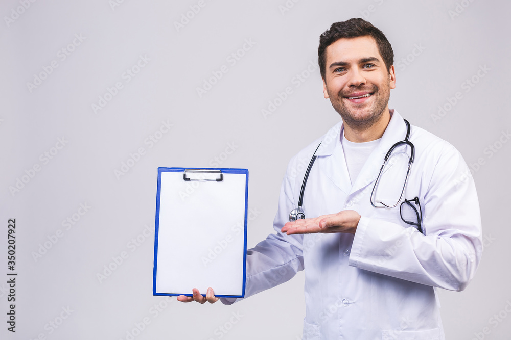 Portrait of smiling male young doctor holding clipboard isolated on white background. Portrait of smiling male young doctor holding clipboard isolated on white background.