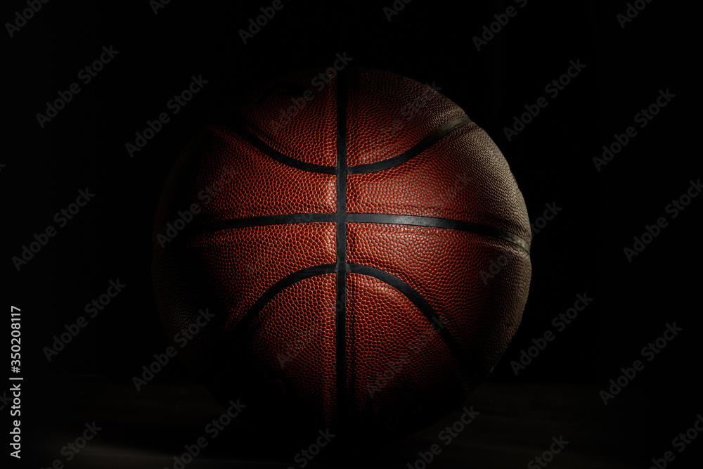 Obraz premium Basketball ball. Professional sport equipment isolated on black studio background. Concept of sport, leadership, competition, healthy lifestyle in motion and action, training. Close up, copyspace.