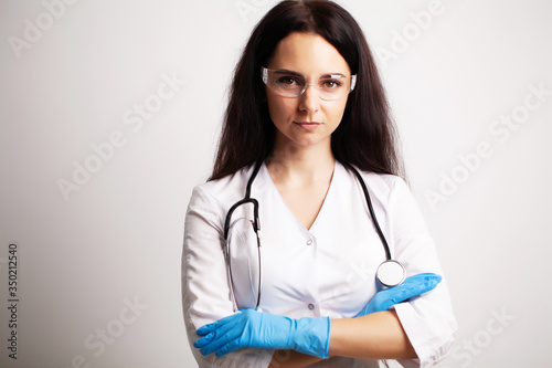 Doctor with protective goggles and stethoscope on her workspace