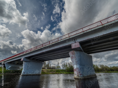 Foto Road bridge over the river under a stormy sky