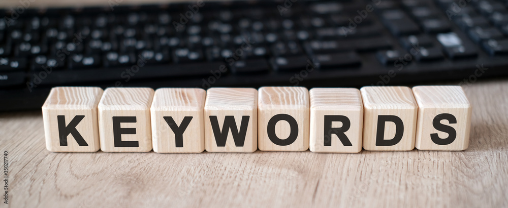 Keywords seo - concept text on wooden cubes and in the background black keyboard Keywords seo - concept text on wooden cubes and in the background black keyboard