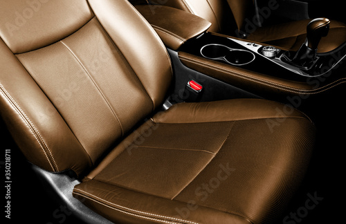Luxury car brown leather interior. Part of leather car seat details with stitching. Comfortable perforated orange leather seats. Brown perforated leather. Car inside © Aleksei