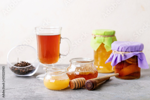 Glass cup of black tea served with honey