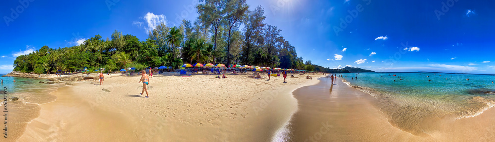 PHUKET, THAILAND - DECEMBER 19, 2019: Tourists enjoy the beautiful Surin Beach on a sunny day. Panoramic view
