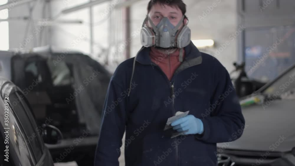 Worker at car service station standing in front of the camera Worker at car service station standing in front of the camera