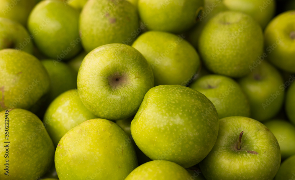 appetizing green apples on counter in market