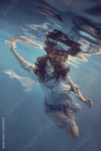 Portrait of a girl in a blue dress under water