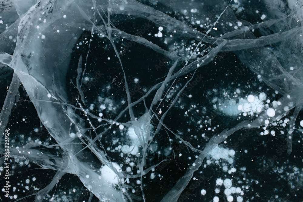 Close Up photo of ice cracks for wallpaper design. Grunge texture of ice. Winter landscape. Nature background. Blue color background. Frozen water. Ice clear surface Close Up photo of ice cracks for wallpaper design. Grunge texture of ice. Winter landscape. Nature background. Blue color background. Frozen water. Ice clear surface