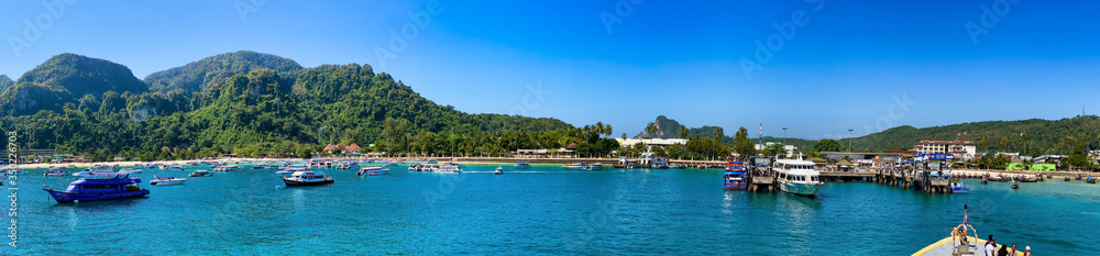 PHI PHI DON, THAILAND - DECEMBER 23, 2019: Tonsai Pier with boats on a beautiful morning. Panoramic view