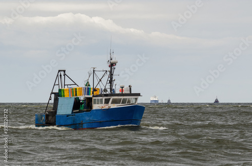 FISHING - A fishing boat at sea and LNG tanker in the background