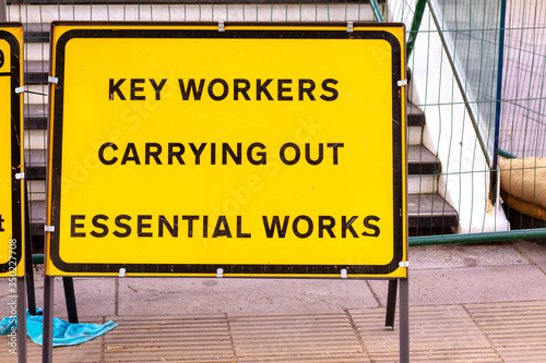 London, U.K. - 14 May 2020: A roadsign alerts people to key workers carrying out essential works