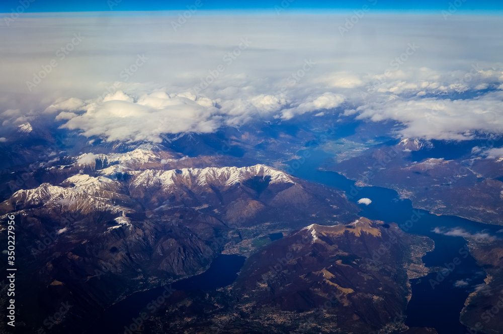 Como Lake between Italy and Switzerland view from an airplane with clouds and blue sky