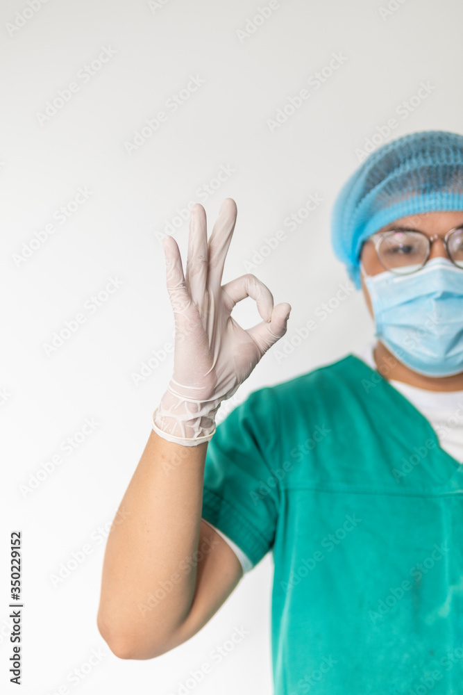 happy male doctor with medical mask in hospital showing ok hand sign, safety sign. happy male doctor with medical mask in hospital showing ok hand sign, safety sign.