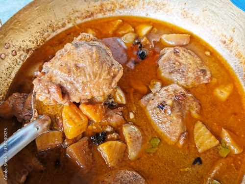massaman curry chicken in brass wok. Massaman is world famous and well known Thai food. photo