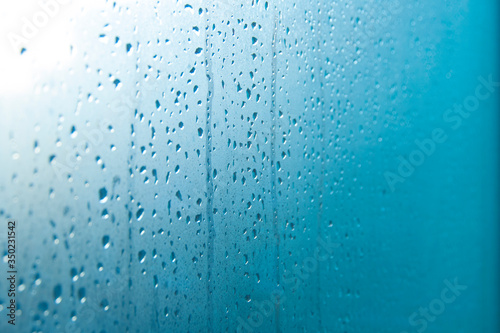 Drops of water flowing from a glass window. Condensate, heat, cold, humidity concept.