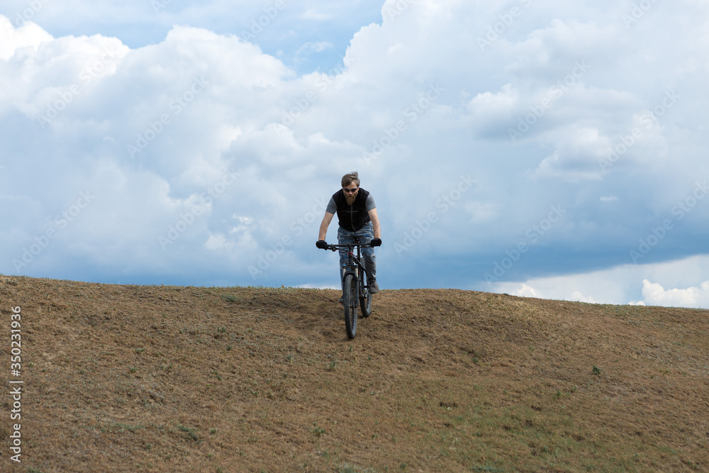 Sports brutal bearded guy on a modern mountain bike. A cyclist in a salt deserted place by the lake. Sports brutal bearded guy on a modern mountain bike. A cyclist in a salt deserted place by the lake.