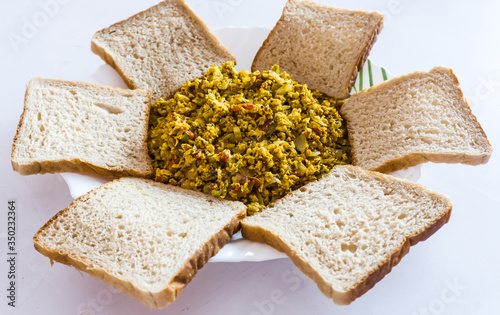 Egg bhurji with bread. Egg bhurji is a dish originating from the Indian subcontinent, a variant of scrambled eggs that is sometimes compared with the Parsi dish akuri. photo